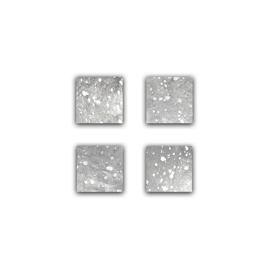 Ein Viererset Glasuntersetzer in glänzendem Silber auf einer Fläche symmetrisch angeordnet 